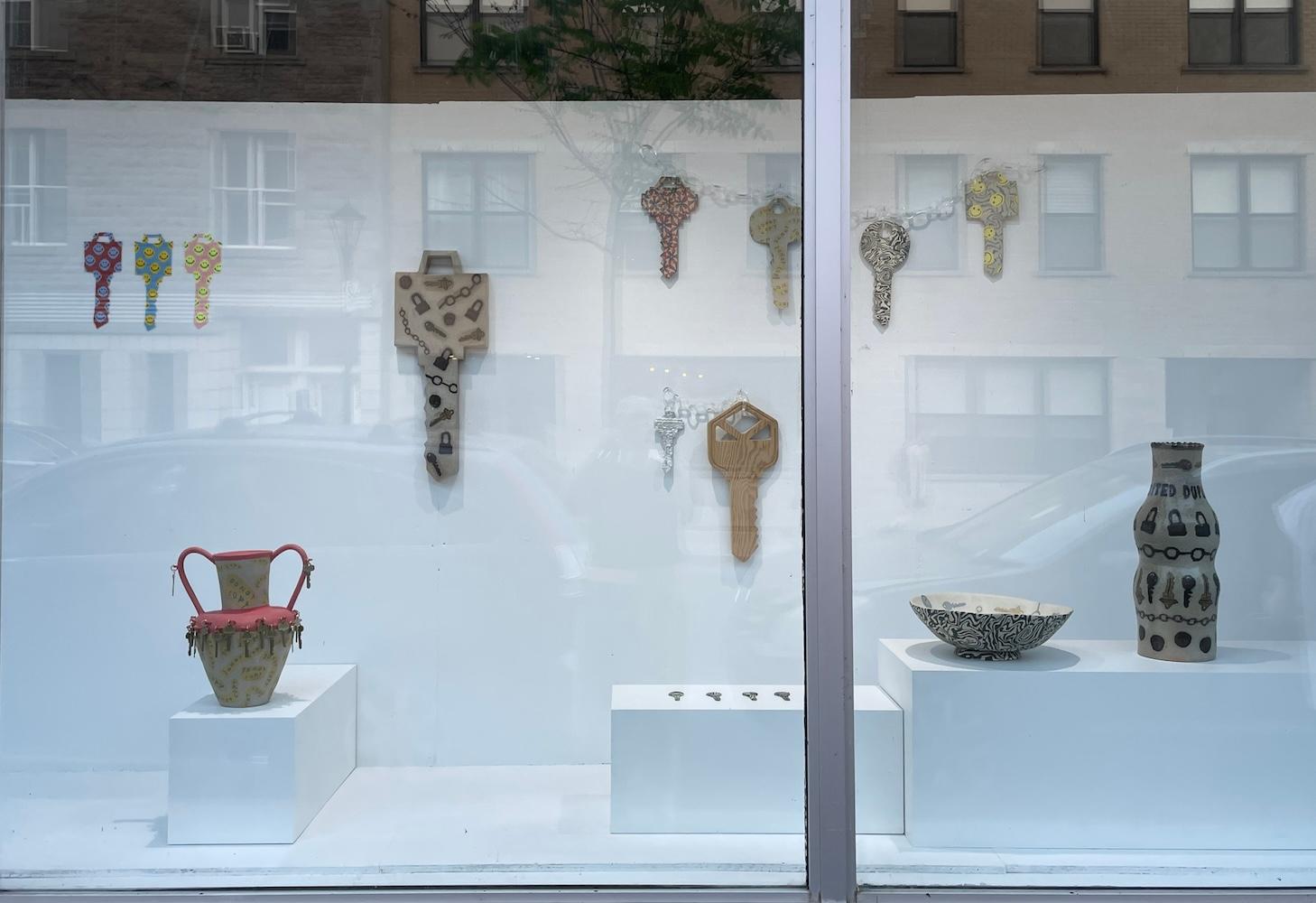 Window display in gallery with ceramic vases, beaded keys and carved wood & papier mache sculptures