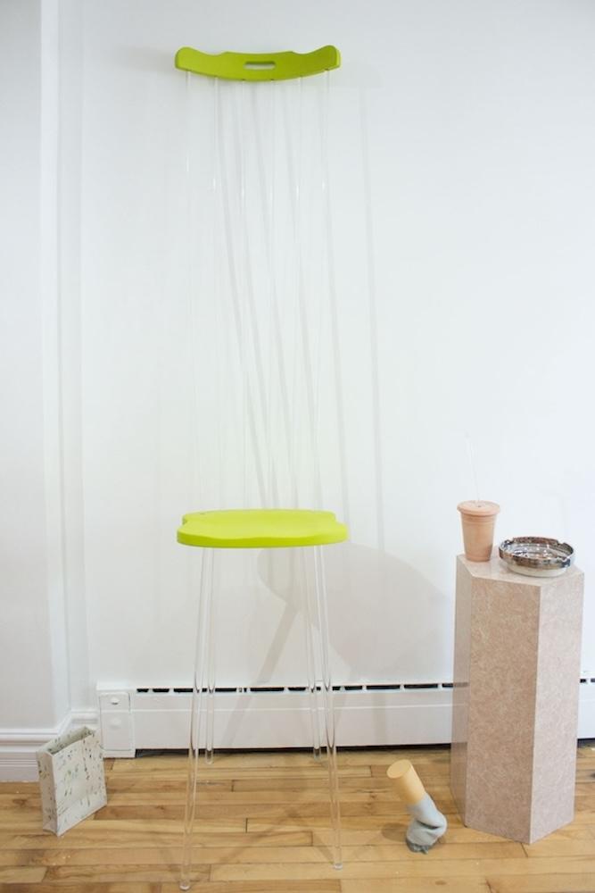 Comically tall lime green & clear lucite chair with speckled ceramic bag and giant ceramic cigarette butt