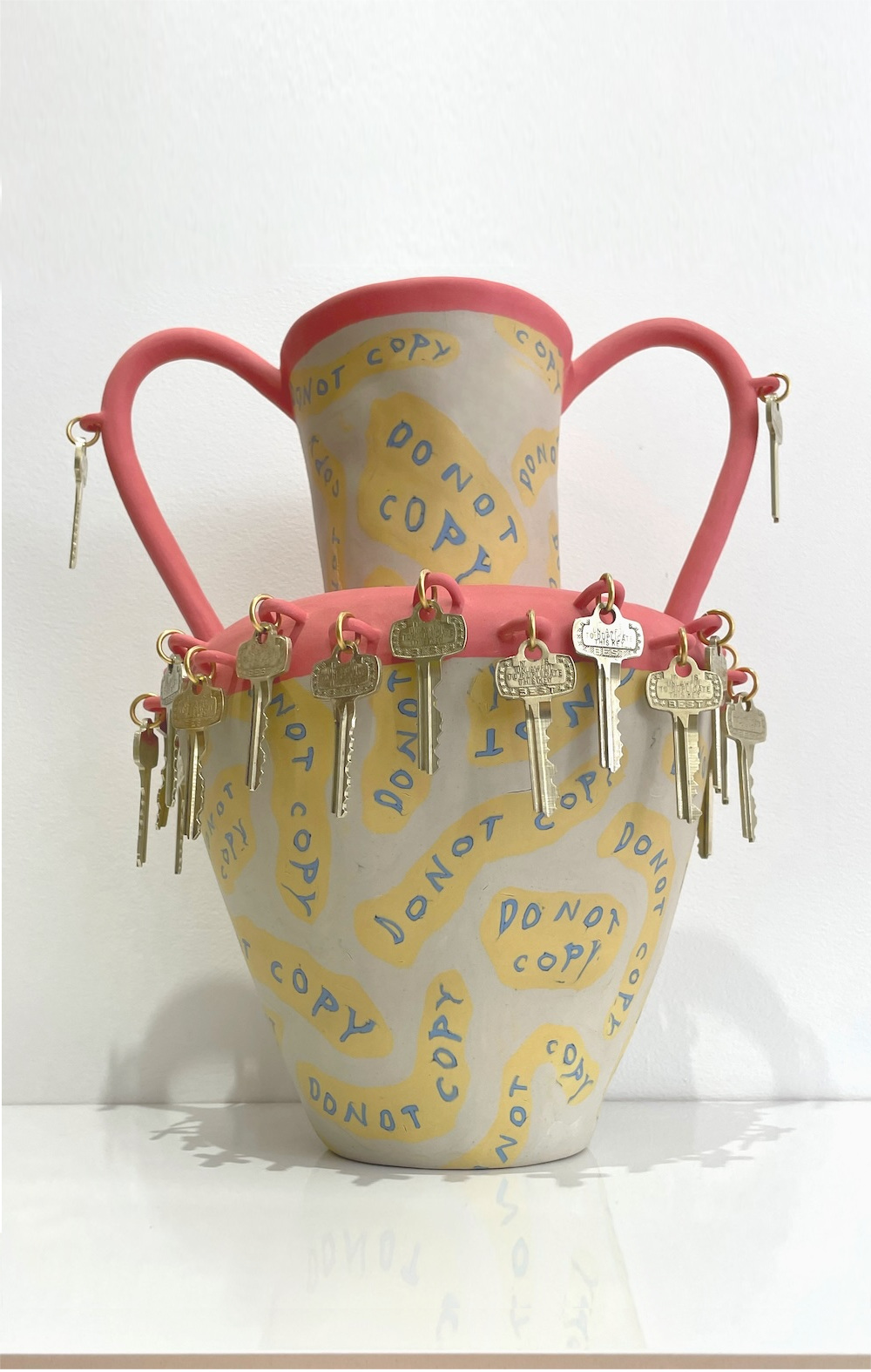 Ceramic nerikomi vase with DO NOT COPY inlaid repeatedly in coloured clay and brass keys dangling all around